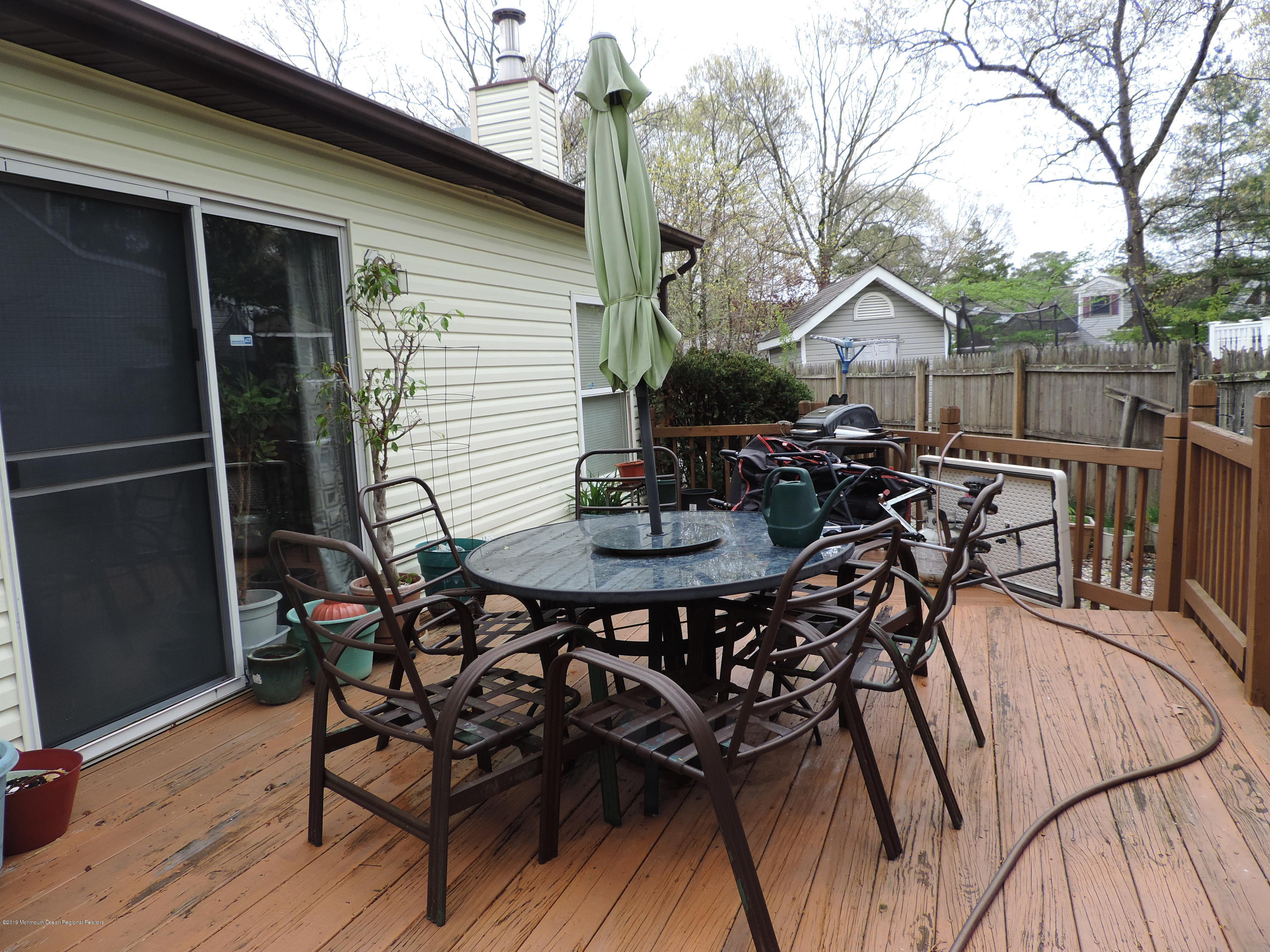 145 Breton Road Brick, NJ 08723 - Photo 23 of 33 a view of a patio with table and chairs and wooden floor