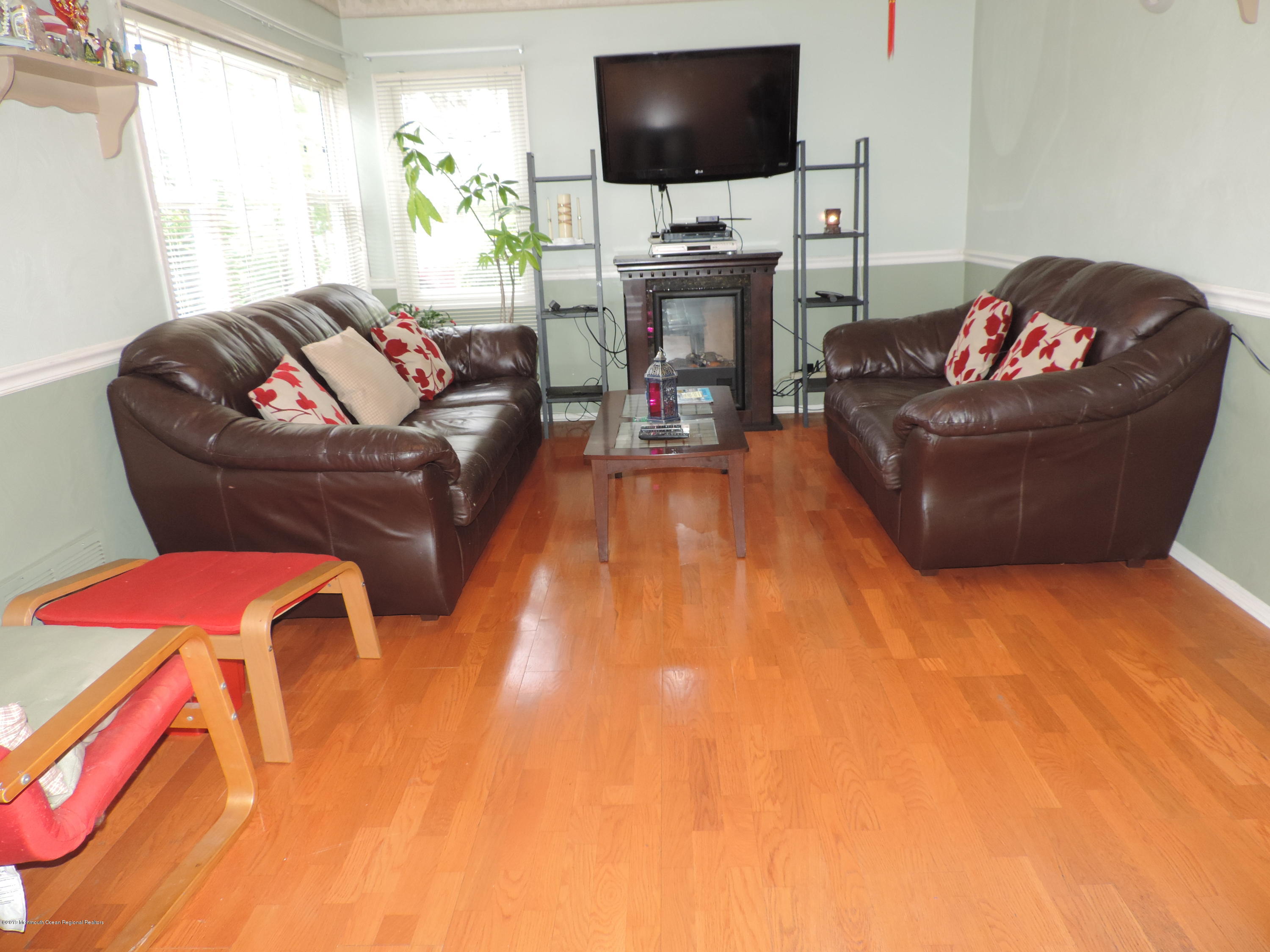 145 Breton Road Brick, NJ 08723 - Photo 7 of 33 a living room with furniture a flat screen tv and a fireplace