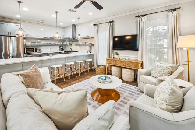 a living room with furniture kitchen view and a chandelier