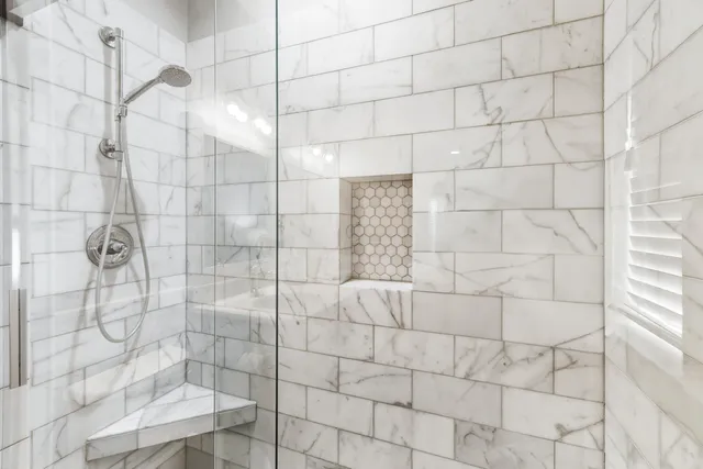 a bedroom with a bed lamp and a large window with wooden floor