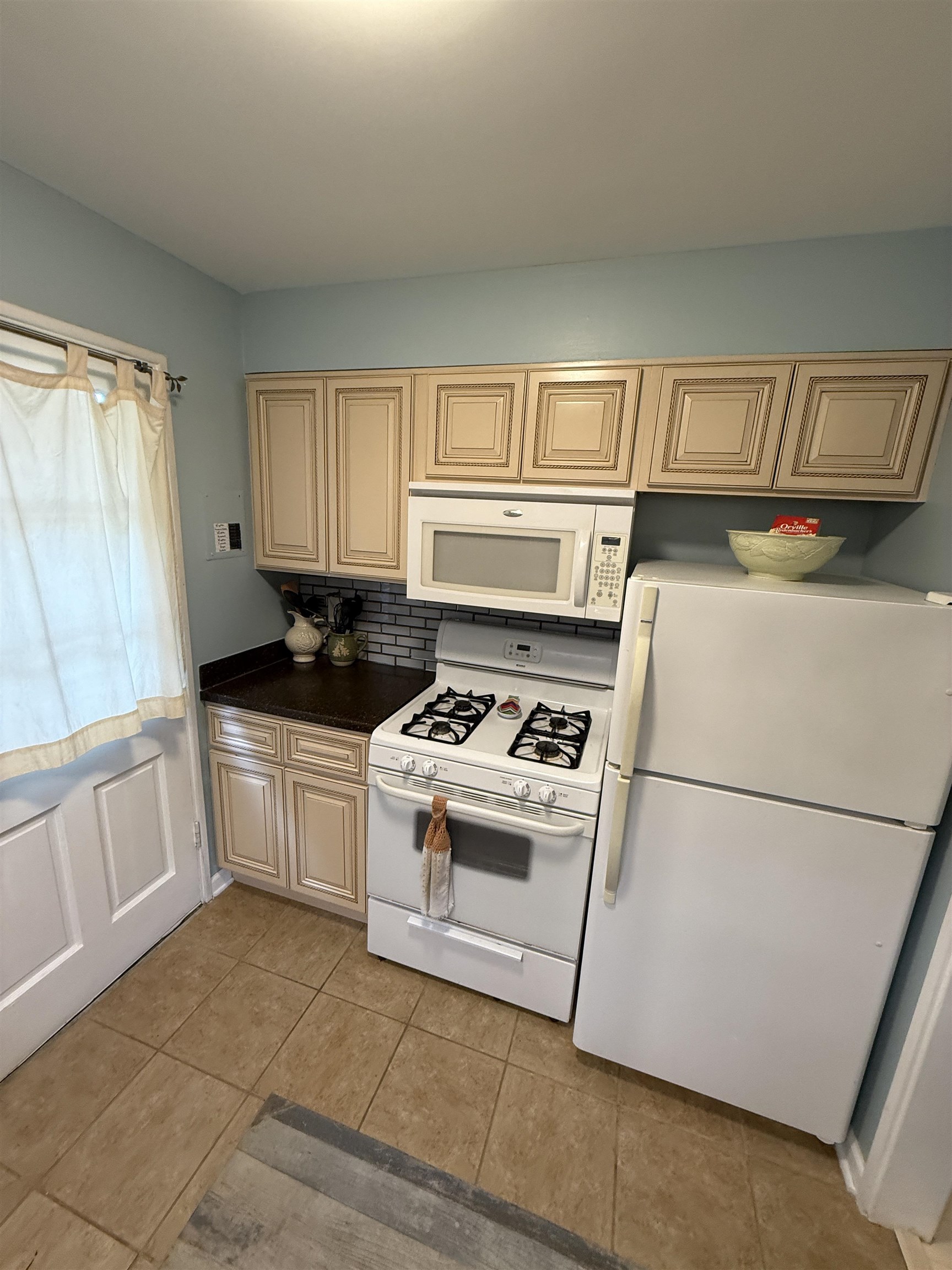 2993 Walnut Grove Road, Unit 2 Memphis, TN 38111 - Photo 4 of 25 Kitchen with white appliances, cream cabinetry, light tile patterned floors, and tasteful backsplash