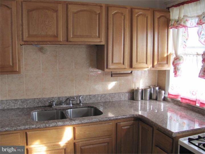 227 Copley Road Upper Darby, PA 19082 - Photo 7 of 8 a kitchen with stainless steel appliances granite countertop a sink and cabinets