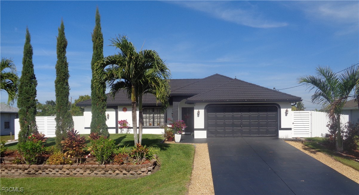 a front view of a house with a yard and potted plants