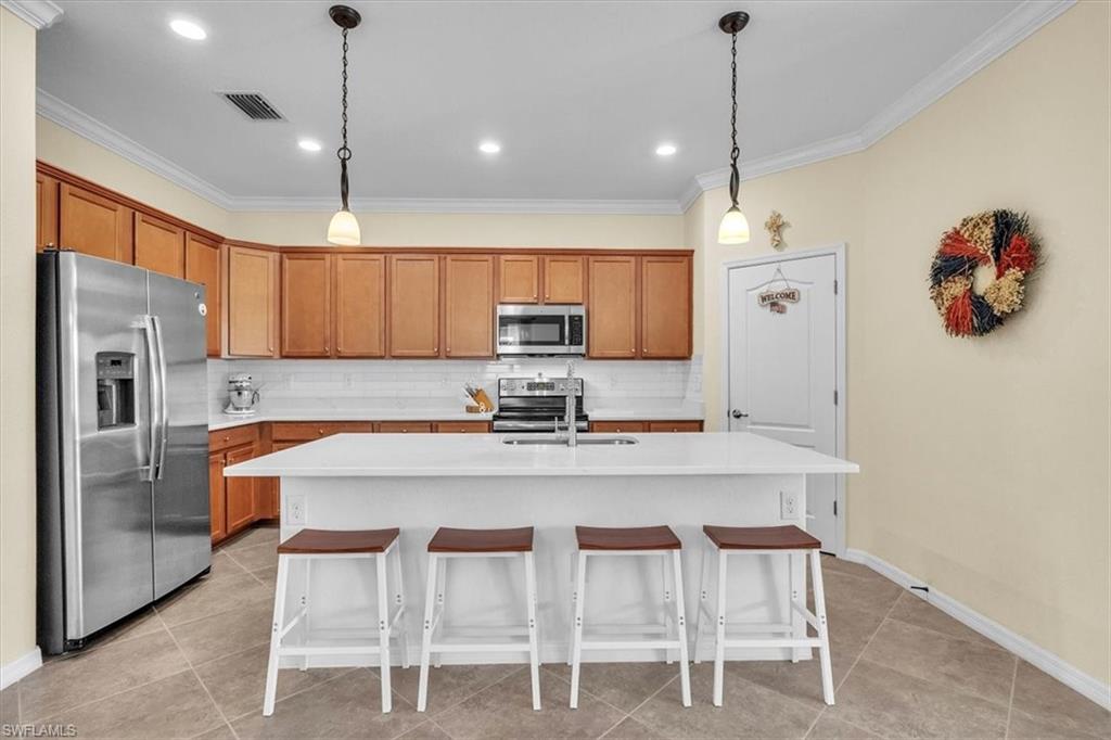 3112 Walnut Grove Lane Alva, FL 33920 - Photo 12 of 50 a kitchen with refrigerator a sink and chairs