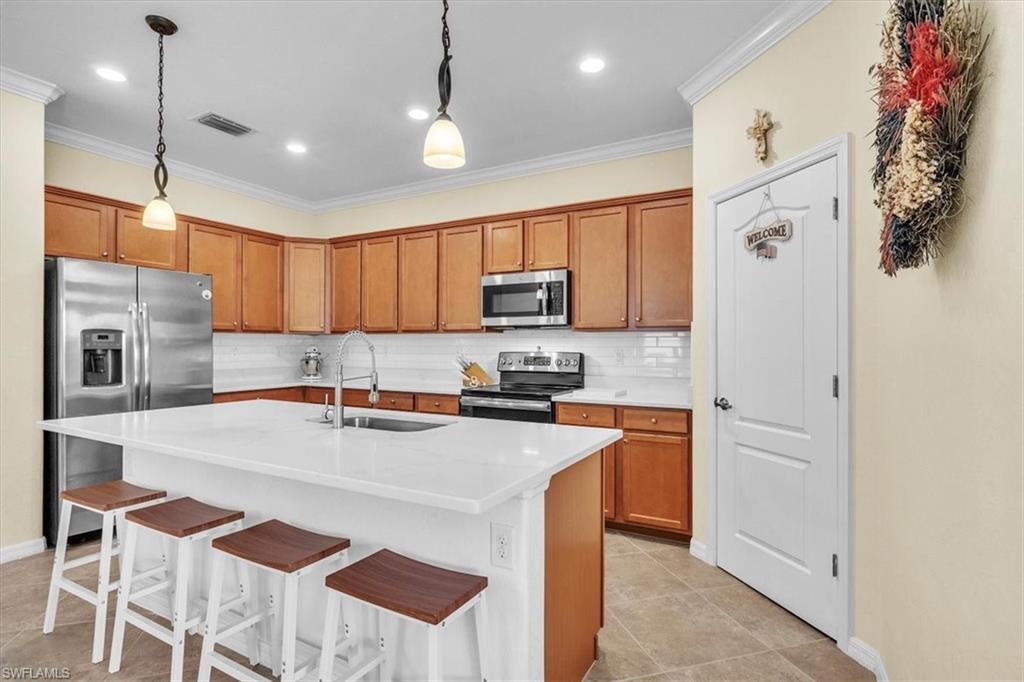 3112 Walnut Grove Lane Alva, FL 33920 - Photo 13 of 50 a kitchen with stainless steel appliances granite countertop a refrigerator a oven a sink a stove and white cabinets with wooden floor