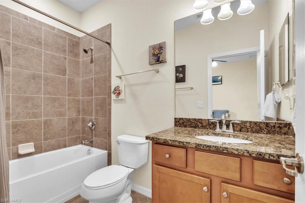3112 Walnut Grove Lane Alva, FL 33920 - Photo 26 of 50 a bathroom with a granite countertop sink a toilet a mirror a bathtub and shower