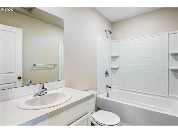 a bathroom with a granite countertop sink mirror toilet and bathtub