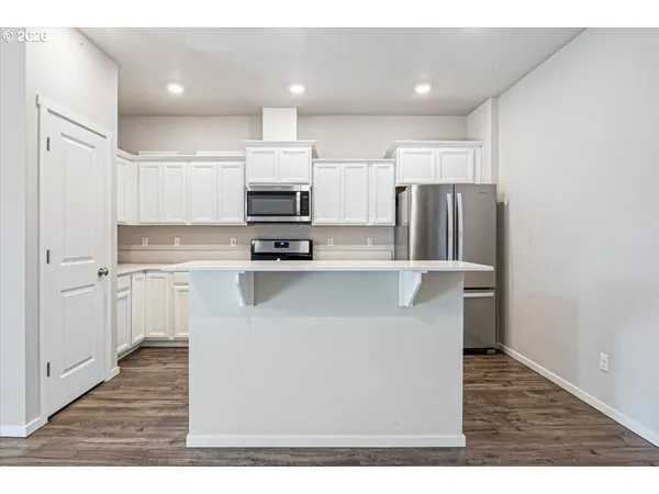 a kitchen with kitchen island a refrigerator sink and cabinets