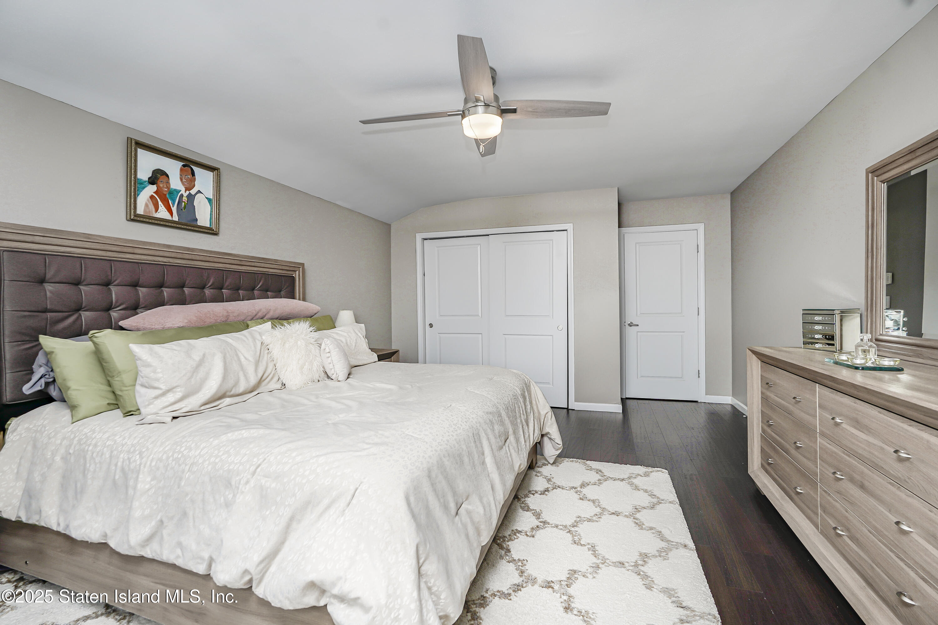 994 Rensselaer Avenue Staten Island, NY 10309 - Photo 17 of 34 a bedroom with a large bed and a chandelier