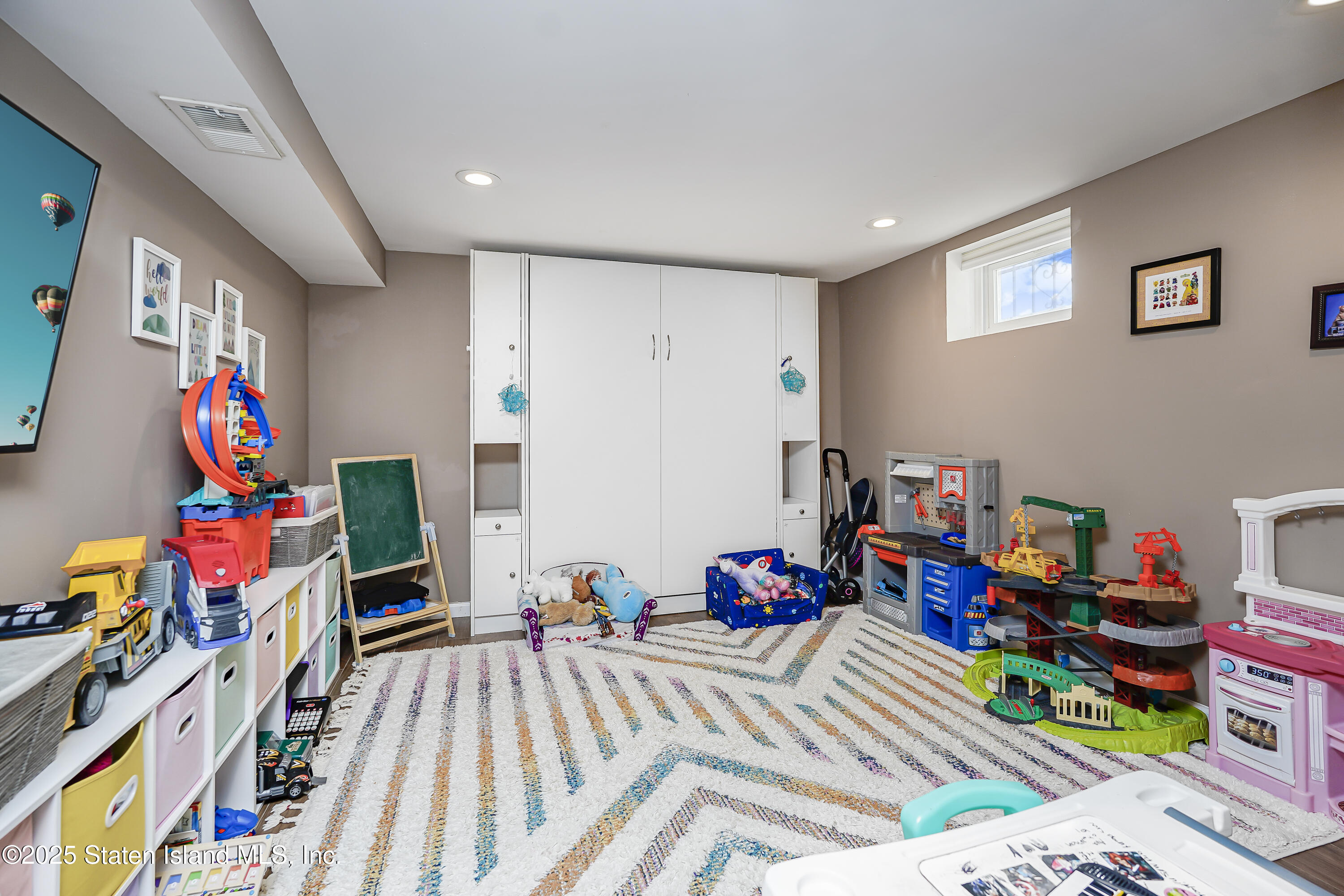 994 Rensselaer Avenue Staten Island, NY 10309 - Photo 28 of 34 a bedroom with baby toys and wooden floor