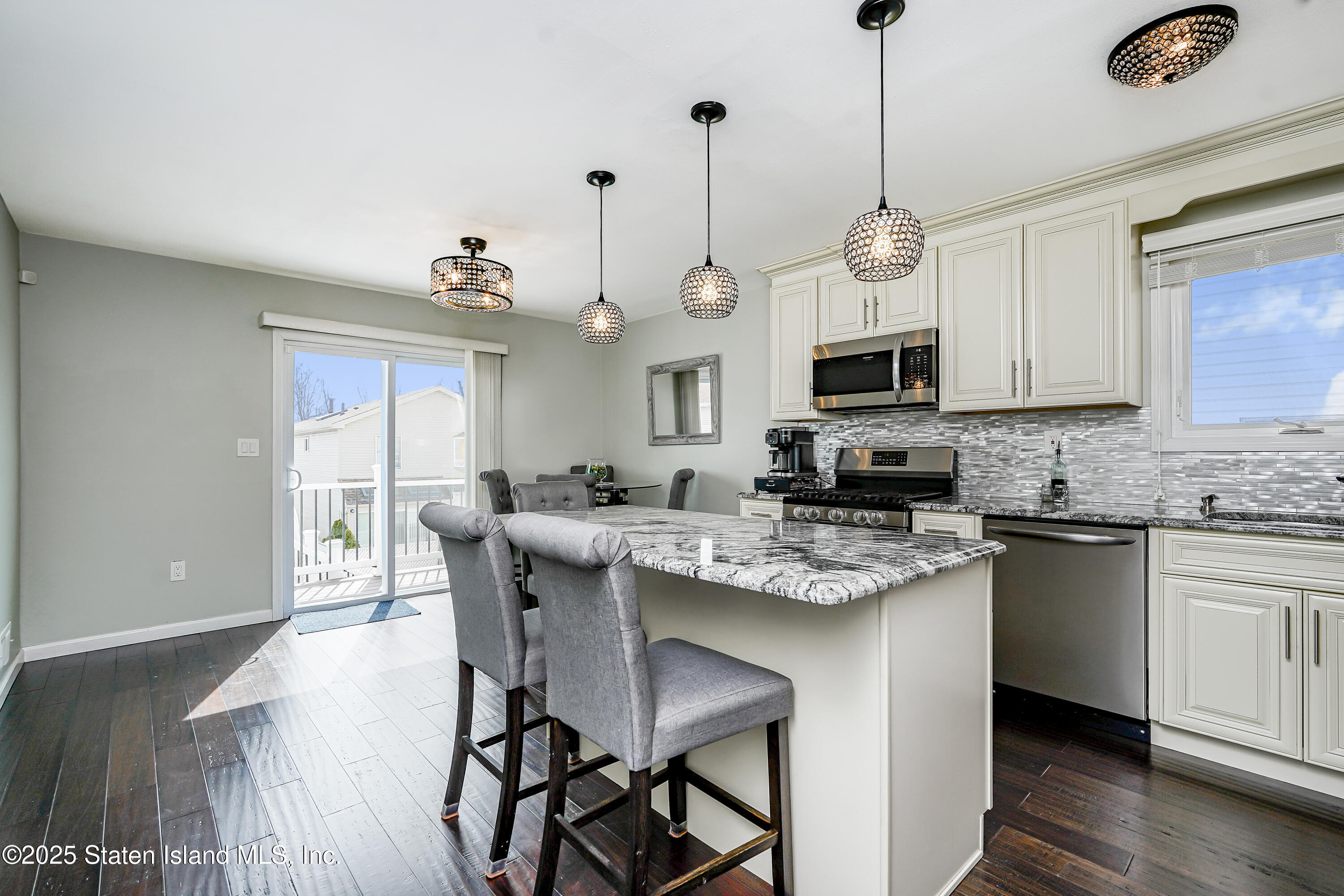 994 Rensselaer Avenue Staten Island, NY 10309 - Photo 7 of 34 a kitchen with stainless steel appliances granite countertop a stove top oven a refrigerator a sink dishwasher and a dining table with wooden floor
