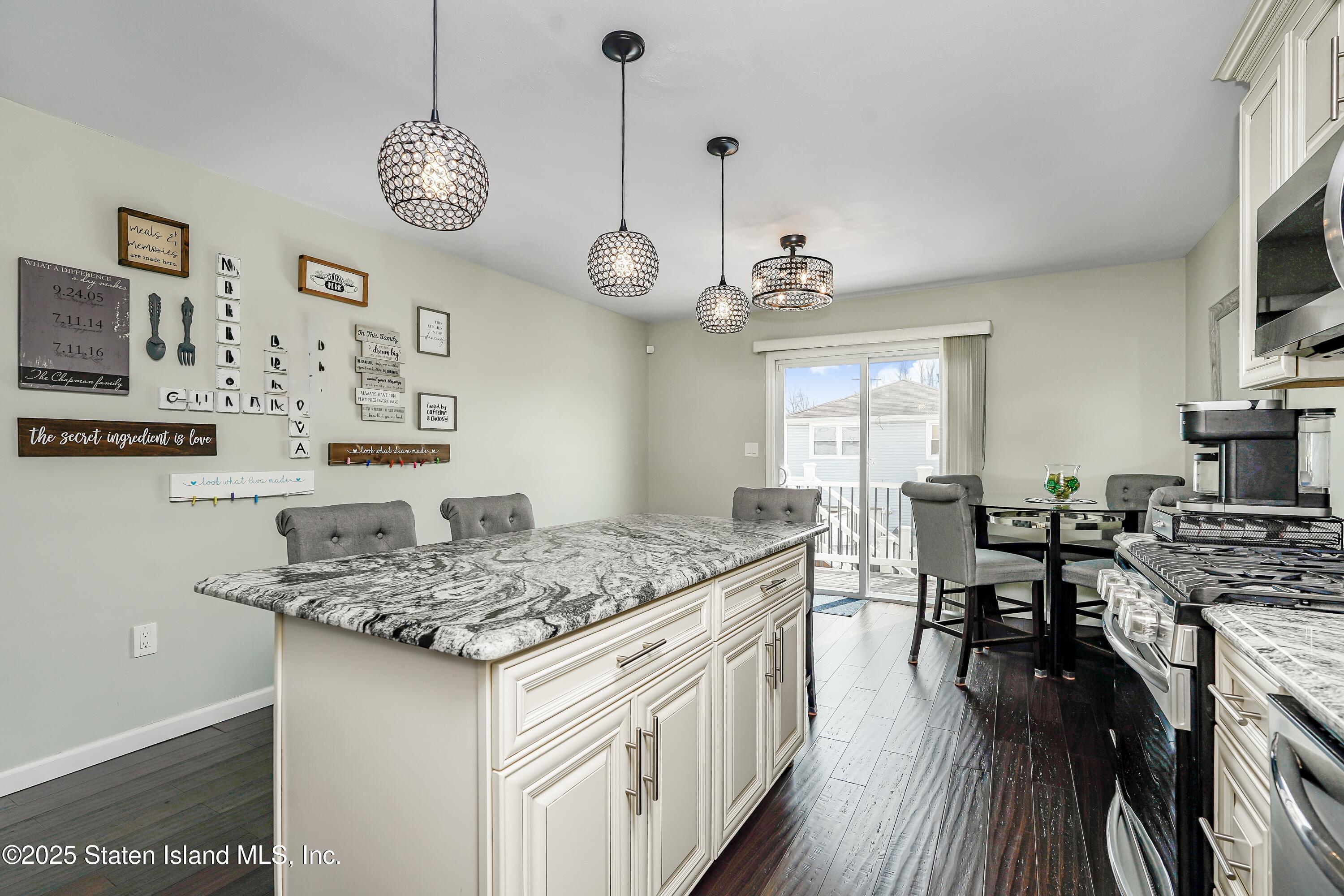 994 Rensselaer Avenue Staten Island, NY 10309 - Photo 9 of 34 a kitchen with stainless steel appliances granite countertop a stove oven a dining table and chairs with wooden floor