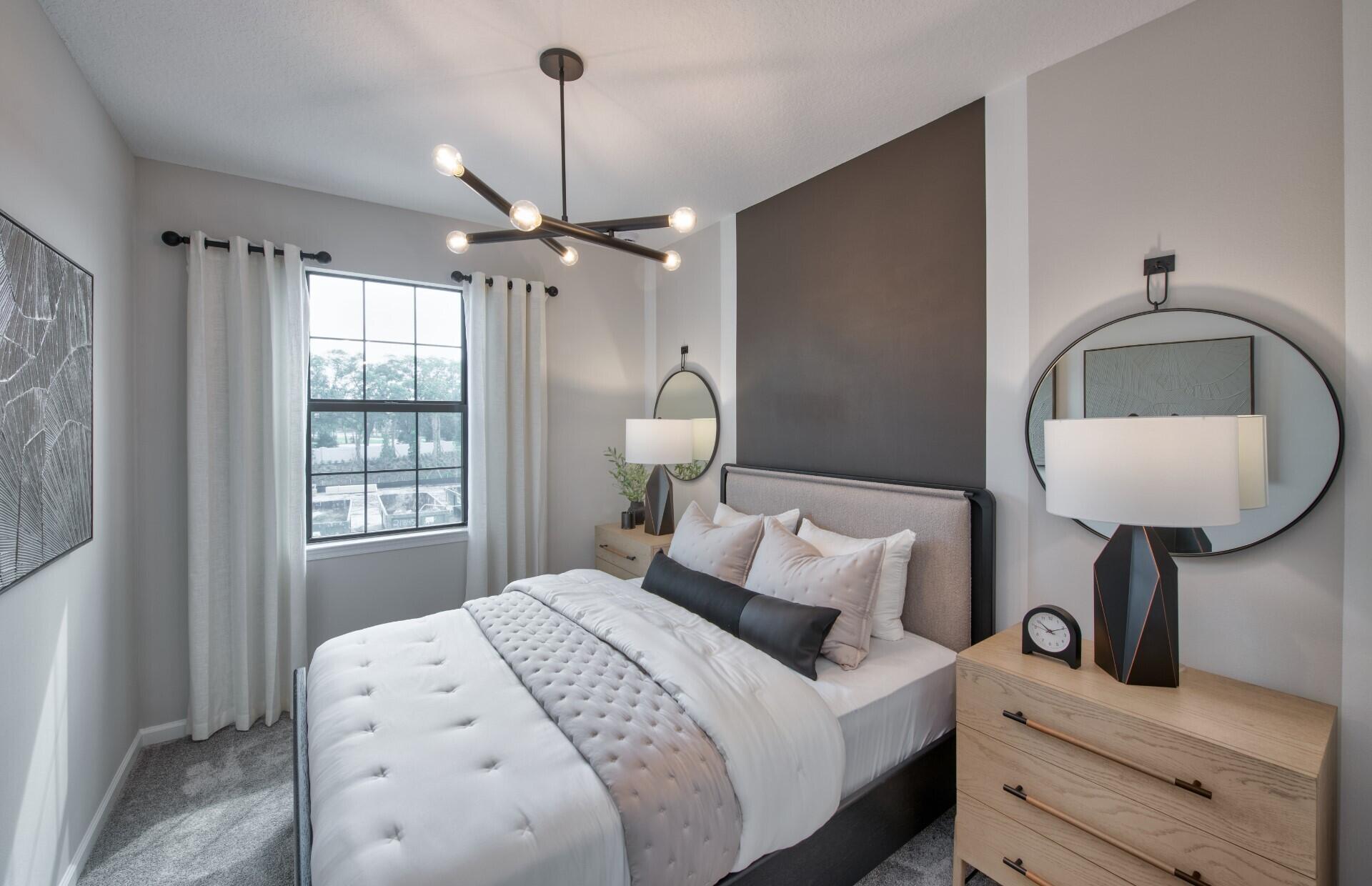 7798 Southwest Bentley Lane, Unit LATITUDE 8316 Stuart, FL 34997 - Photo 10 of 21 a bedroom with a bed and a chandelier