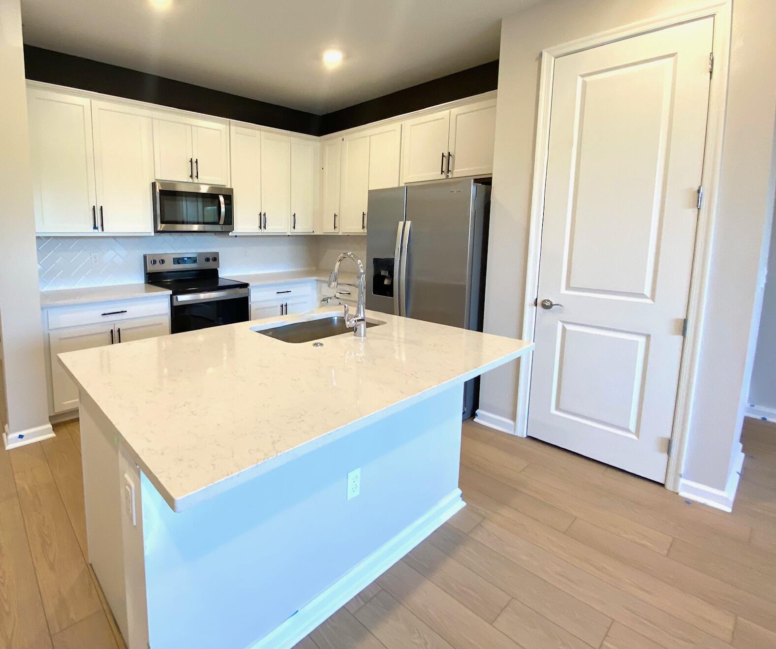 7798 Southwest Bentley Lane, Unit LATITUDE 8316 Stuart, FL 34997 - Photo 5 of 21 a kitchen with stainless steel appliances a refrigerator and a stove top oven