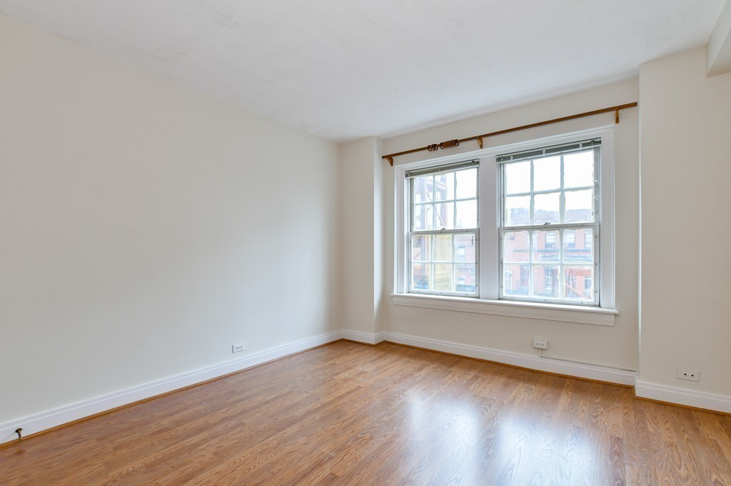 534 Beacon Street, Unit 502 Boston, MA 02215 - Photo 11 of 18 an empty room with wooden floor and windows
