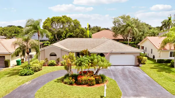 a view of a white house with a yard and potted plants