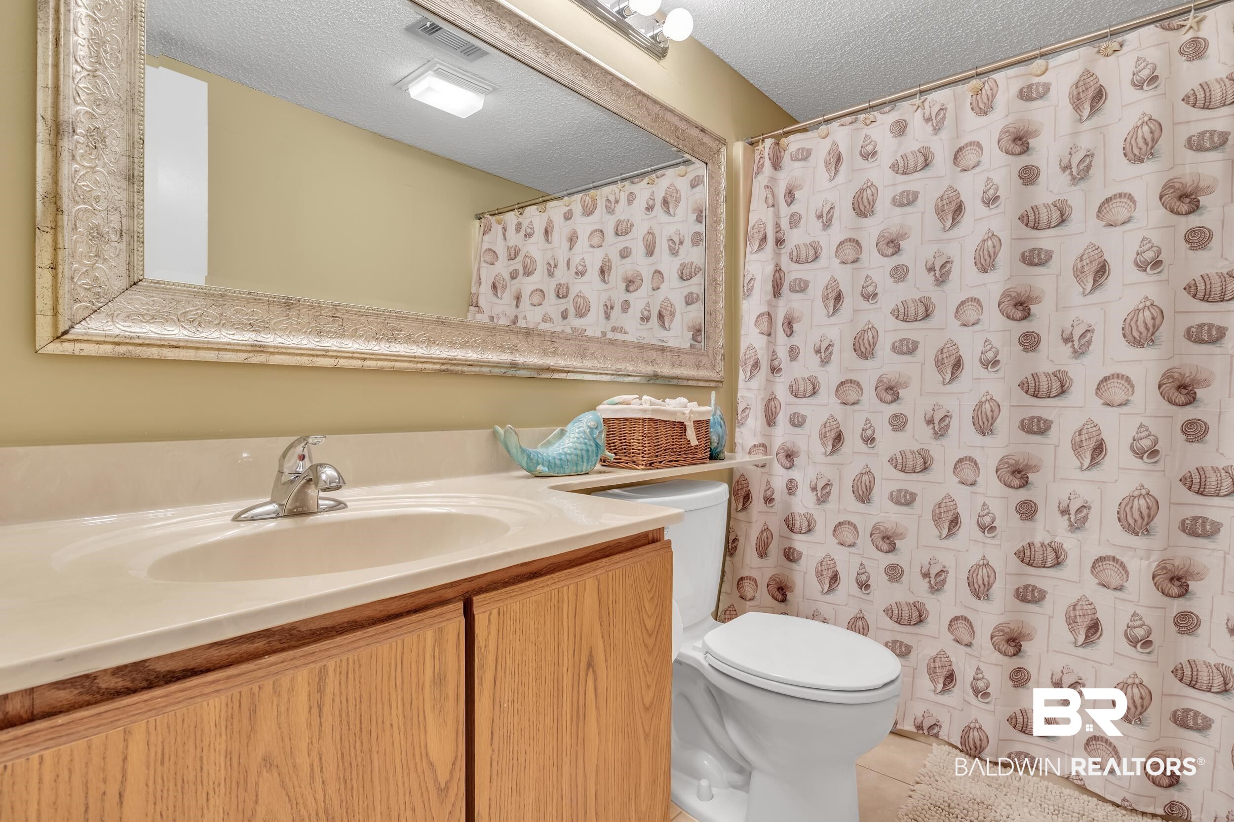 3256 Loop Road, Unit 2 Orange Beach, AL 36561 - Photo 25 of 25 Full bathroom featuring a single vanity with wood-finish cabinetry, an integrated sink, and a light-toned countertop