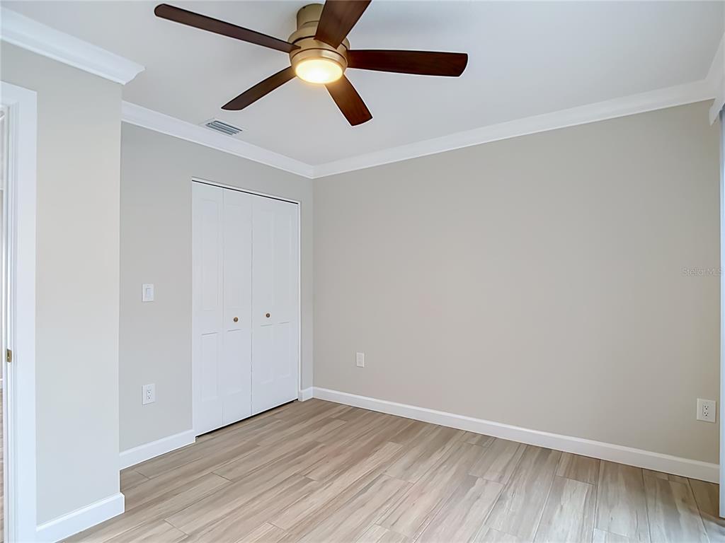 4536 Mitcher Road New Port Richey, FL 34652 - Photo 17 of 46 an empty room with wooden floor ceiling fan and window