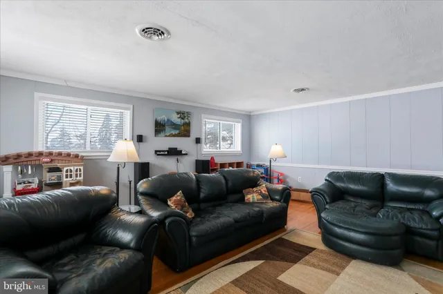 a living room with furniture a ceiling fan and a window