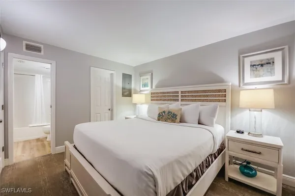 a bedroom with a bed and a lamp on the dresser