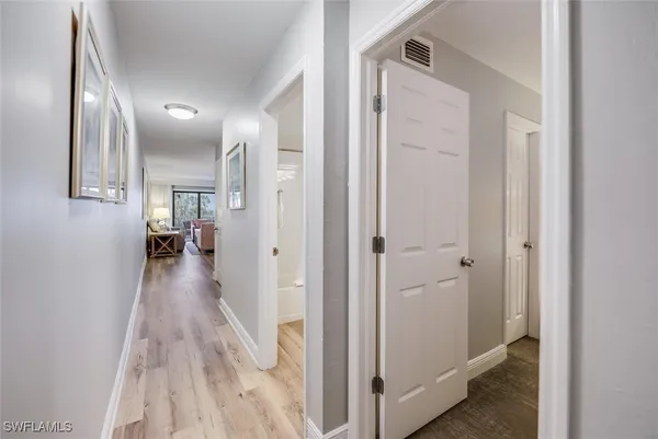 a view of a hallway with wooden floor and staircase