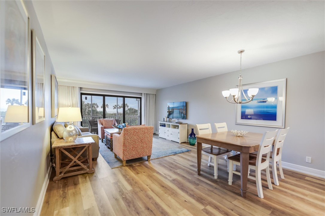 2117 Gulf Beach Villas Captiva, FL 33924 - Photo 4 of 24 a dining room with furniture a chandelier and wooden floor