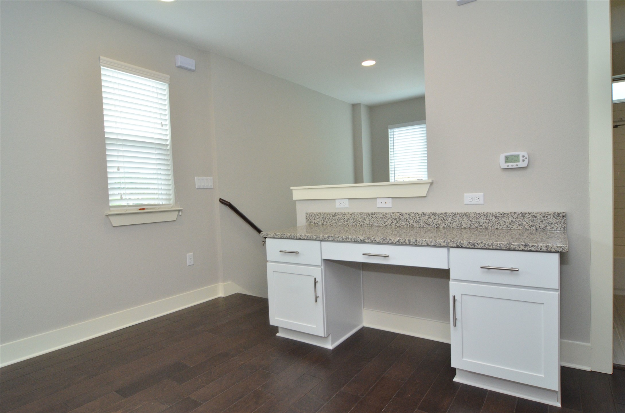1916 Cleese Drive Austin, TX 78741 - Photo 16 of 36 A built-in desk with stone counters and hardwood flooring creates a versatile home office space.