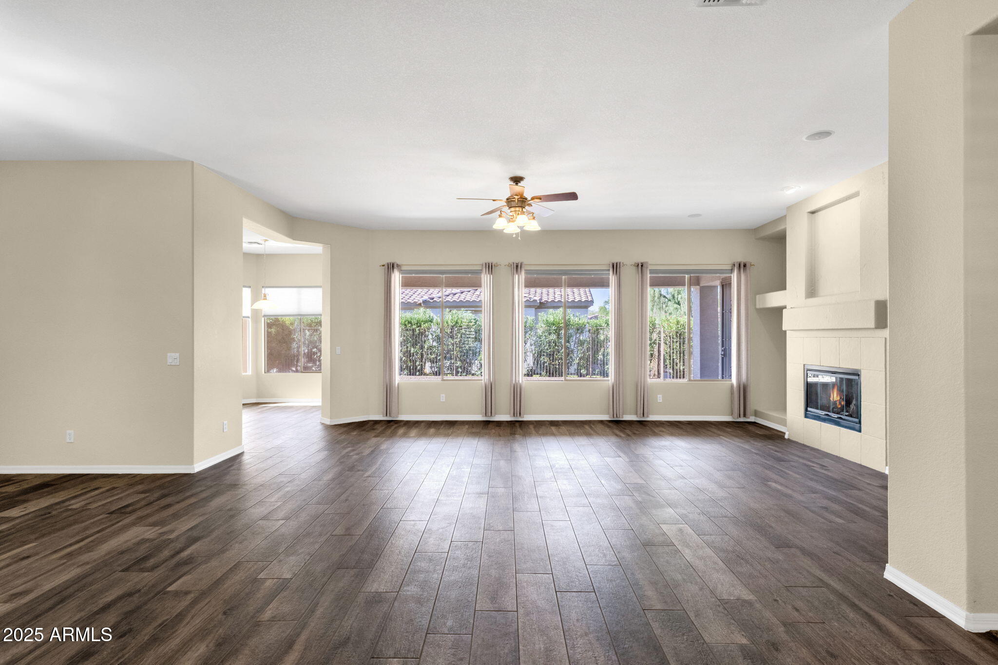 4735 East Azalea Drive Gilbert, AZ 85298 - Photo 10 of 37 an empty room with wooden floor fireplace and windows