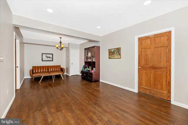 a dining room with wooden floor a chandelier a wooden table and chairs