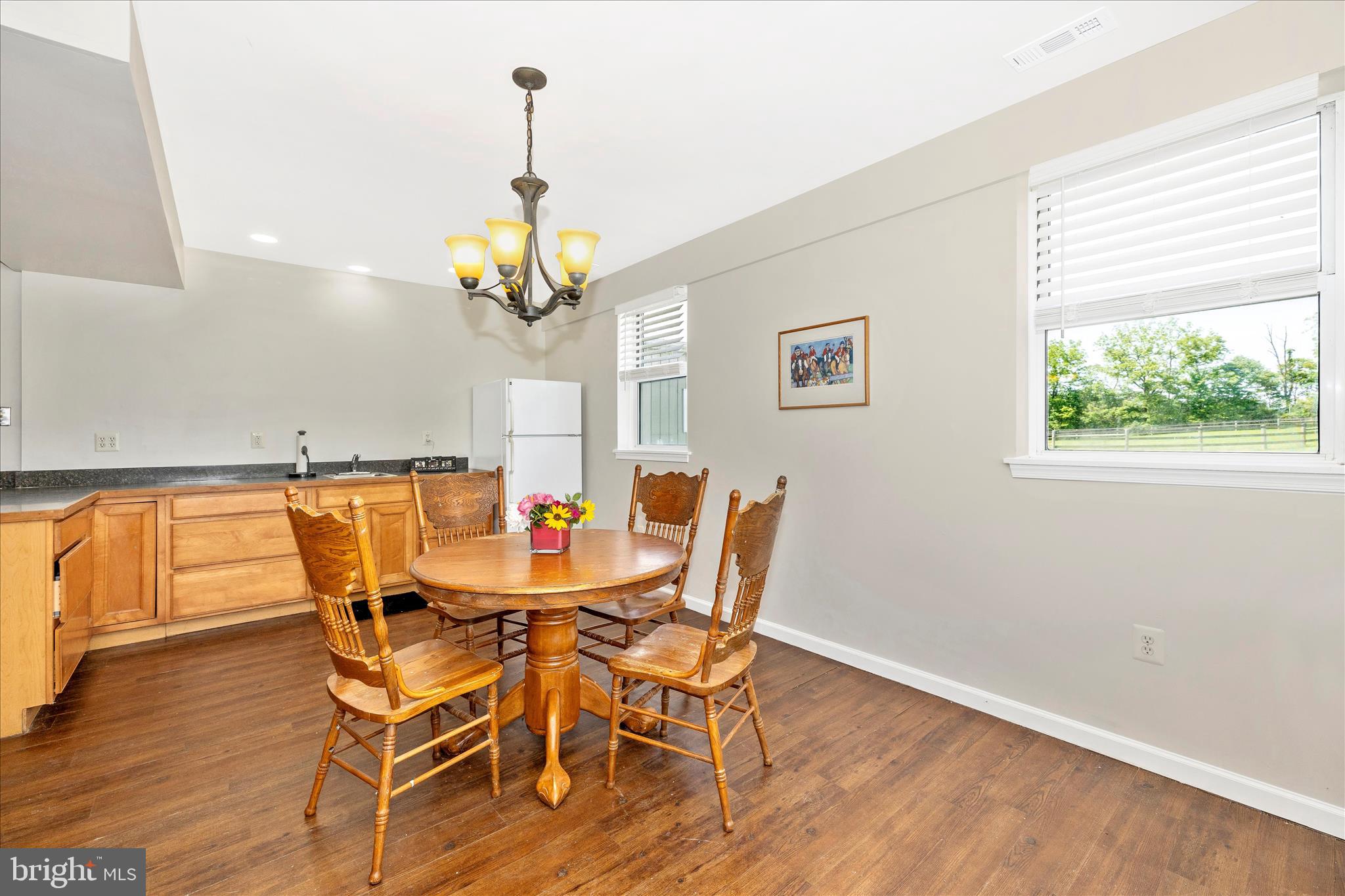 10224 Bessie Clemson Road Union Bridge, MD 21791 - Photo 22 of 46 a dining room with wooden floor a chandelier a glass table and chairs