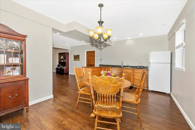 a kitchen with white cabinets and wooden floor