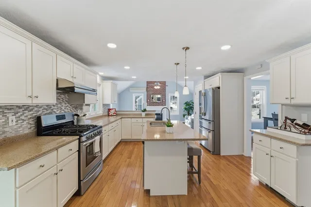 a large kitchen with stainless steel appliances lots of counter space and wooden floor