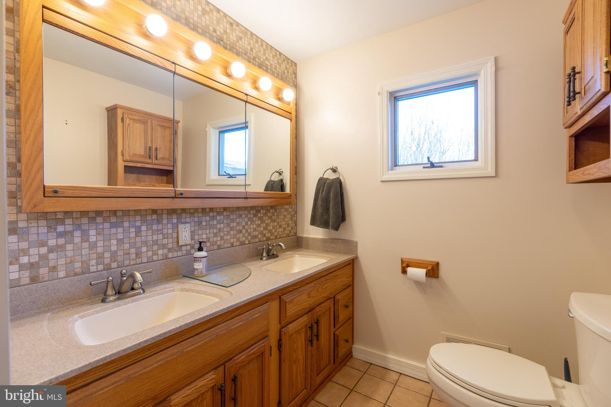 1603 Messiah Church Road Bedford, PA 15522 - Photo 16 of 114 a bathroom with a granite countertop toilet sink and mirror