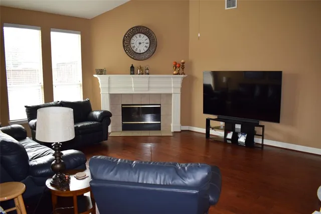 a living room with furniture a fireplace and a flat screen tv