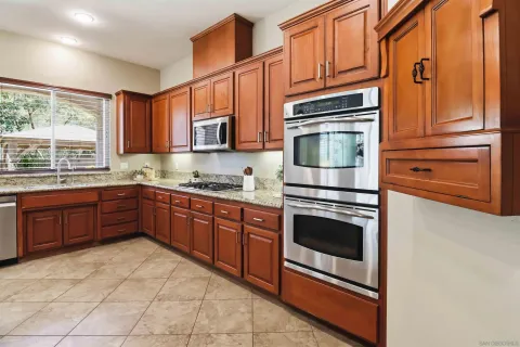 a kitchen with stainless steel appliances granite countertop a sink and a refrigerator