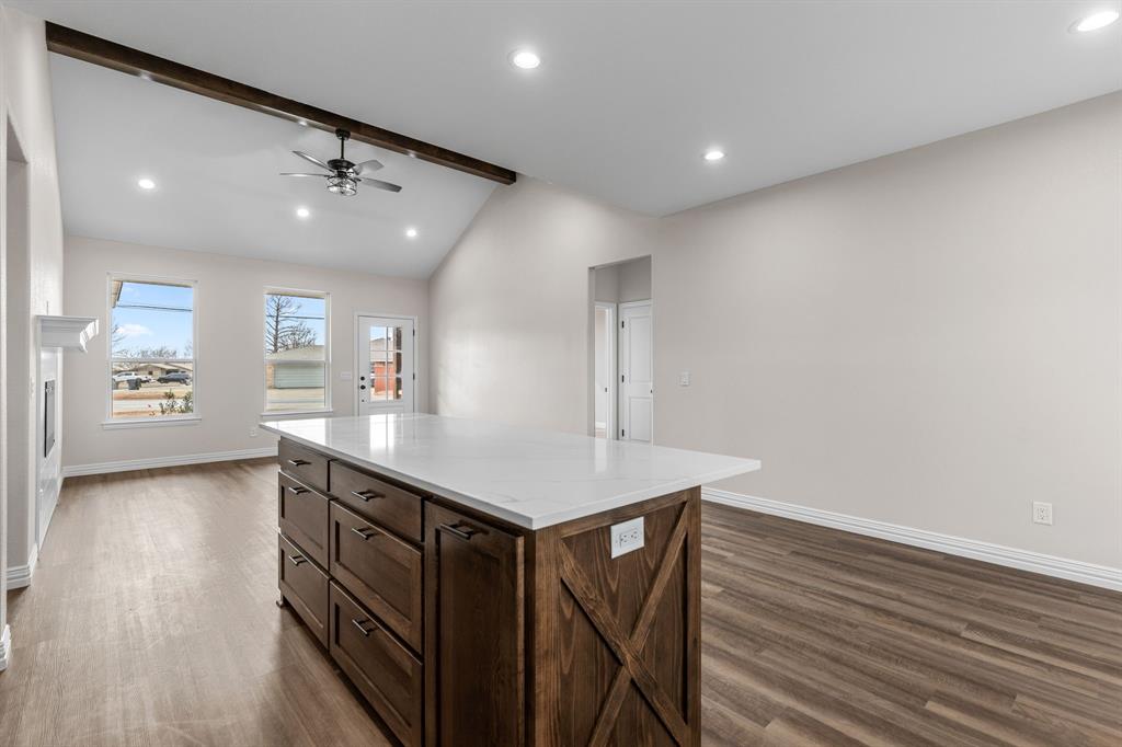 4695 Sisk Road Wichita Falls, TX 76310 - Photo 11 of 32 Kitchen featuring dark wood-type flooring, ceiling fan, a kitchen island, and vaulted ceiling with beams