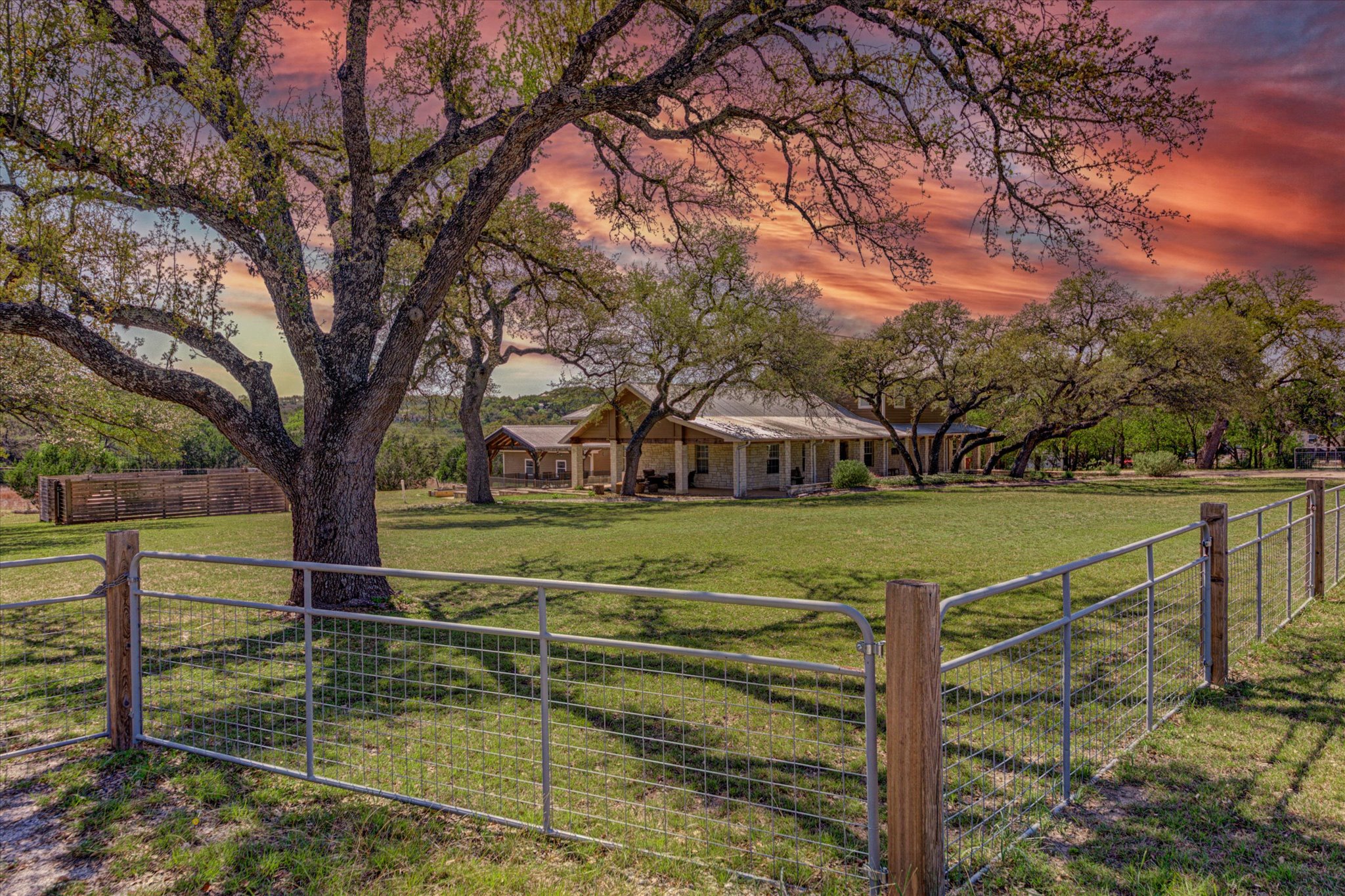 a view of a fountain in front of a house with large trees