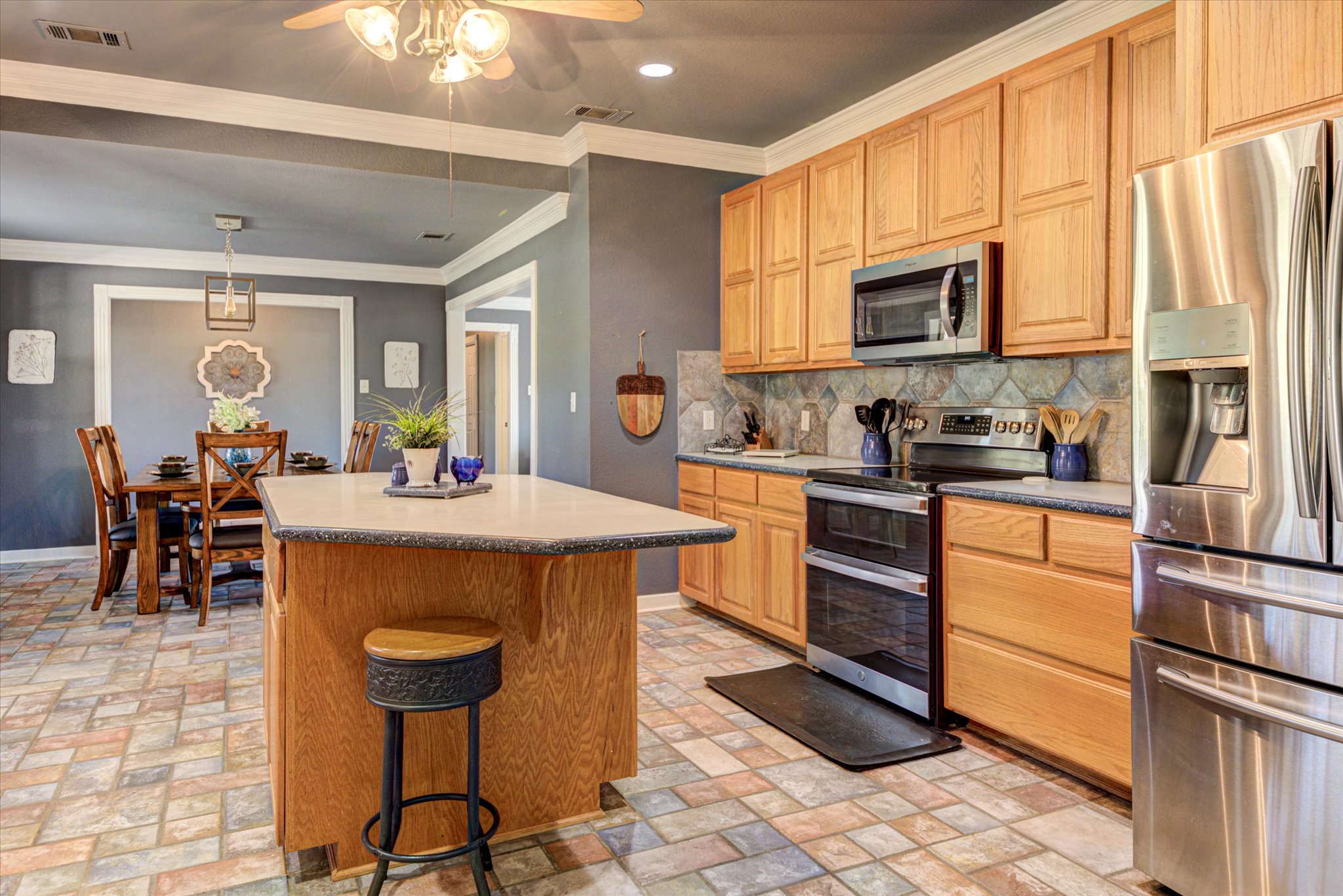 13423 Trail Driver Street Austin, TX 78737 - Photo 8 of 40 a kitchen with stainless steel appliances a stove a sink a microwave and dining table