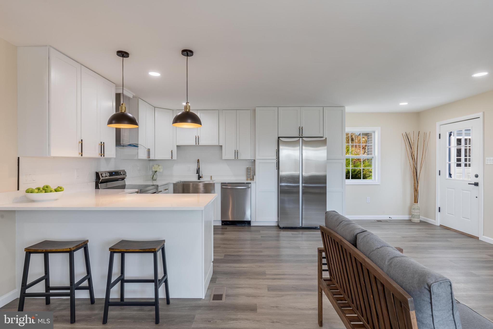 224 Hawk Trail Winchester, VA 22602 - Photo 5 of 29 a kitchen with stainless steel appliances granite countertop a microwave a stove a sink dishwasher and a refrigerator with wooden floor