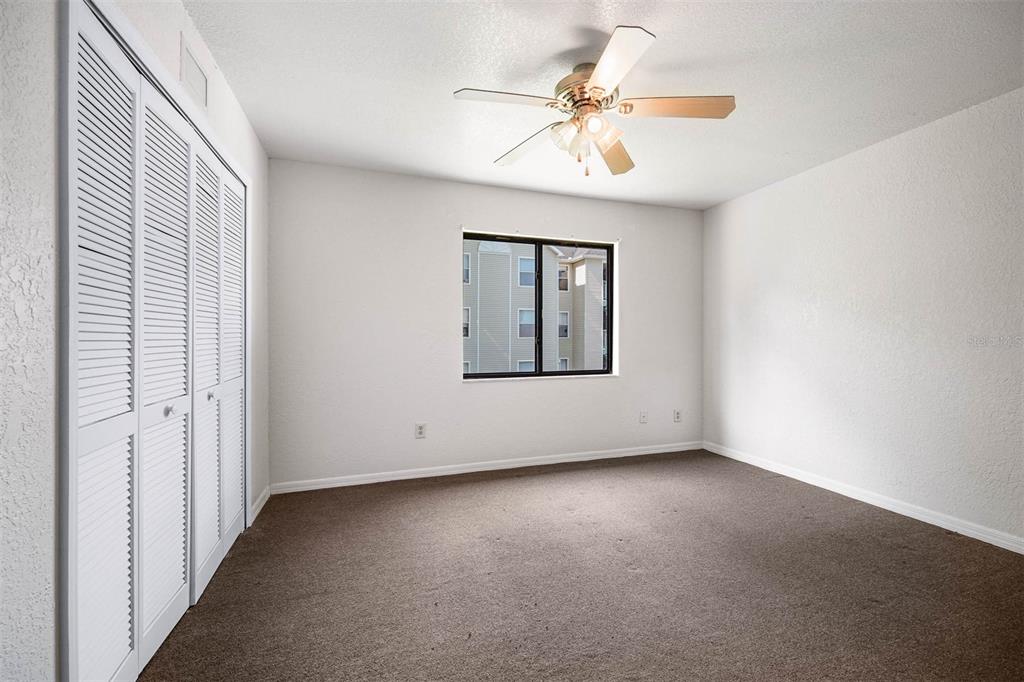 12062 Tift Circle Orlando, FL 32826 - Photo 13 of 26 an empty room with a chandelier fan and windows