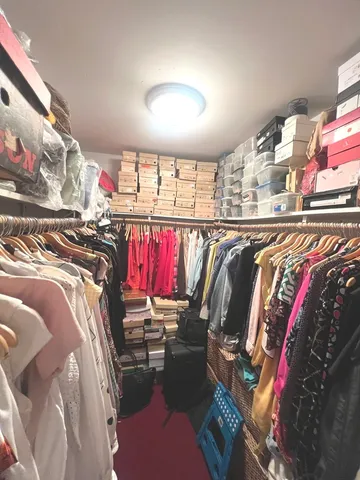 a view of walk in closet with clothes and shoes