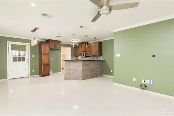 a large kitchen with stainless steel appliances a large counter top a stove and a refrigerator