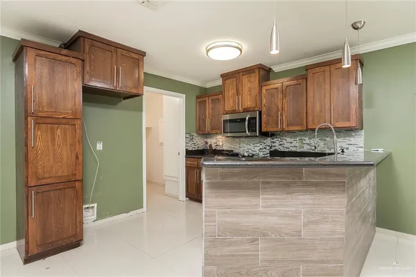 a kitchen with stainless steel appliances granite countertop a refrigerator and microwave
