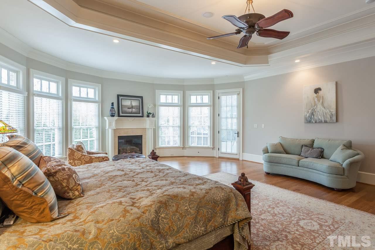 3032 Cone Manor Lane Raleigh, NC 27613 - Photo 16 of 30 a spacious bedroom with a bed a couch and a fireplace