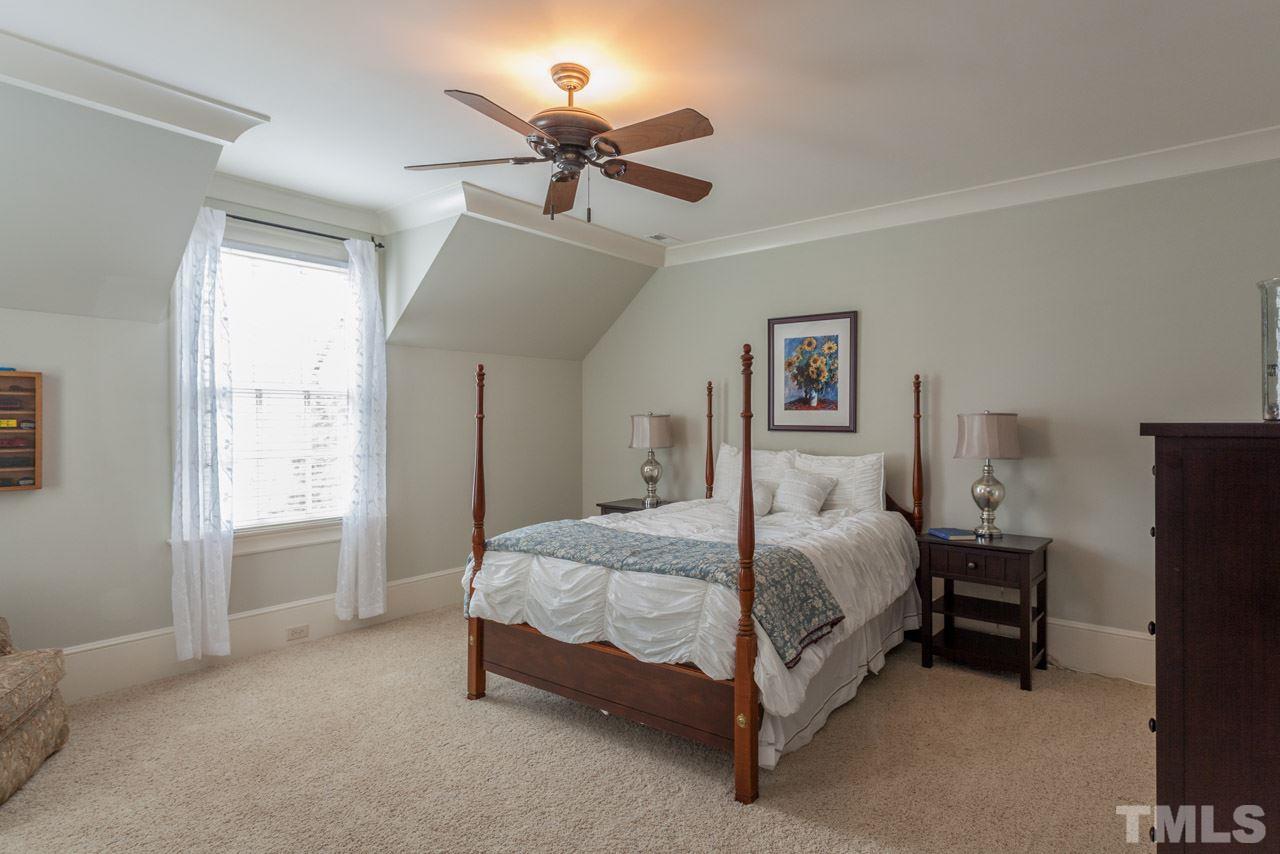 3032 Cone Manor Lane Raleigh, NC 27613 - Photo 20 of 30 a bedroom with a bed and a chandelier