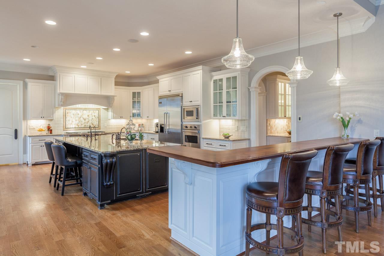 3032 Cone Manor Lane Raleigh, NC 27613 - Photo 7 of 30 a kitchen with kitchen island granite countertop a table and chairs in it