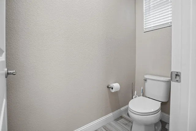 a white toilet sitting next to a white wall