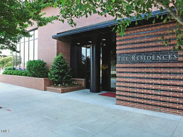 a view of a house with potted plants and a bench