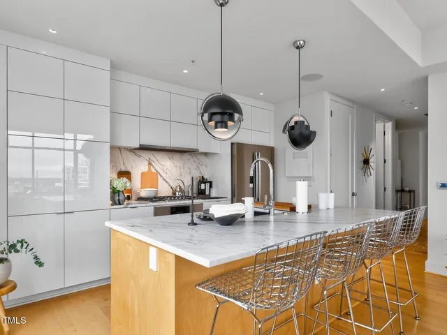 a kitchen with stainless steel appliances granite countertop a sink a counter top space cabinets and living room view