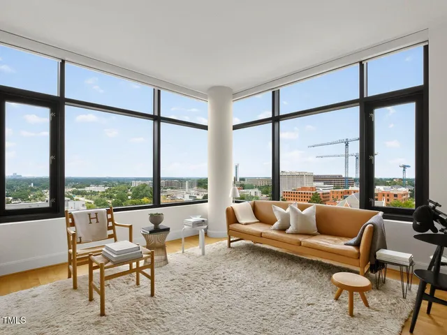 a living room with furniture and floor to ceiling windows